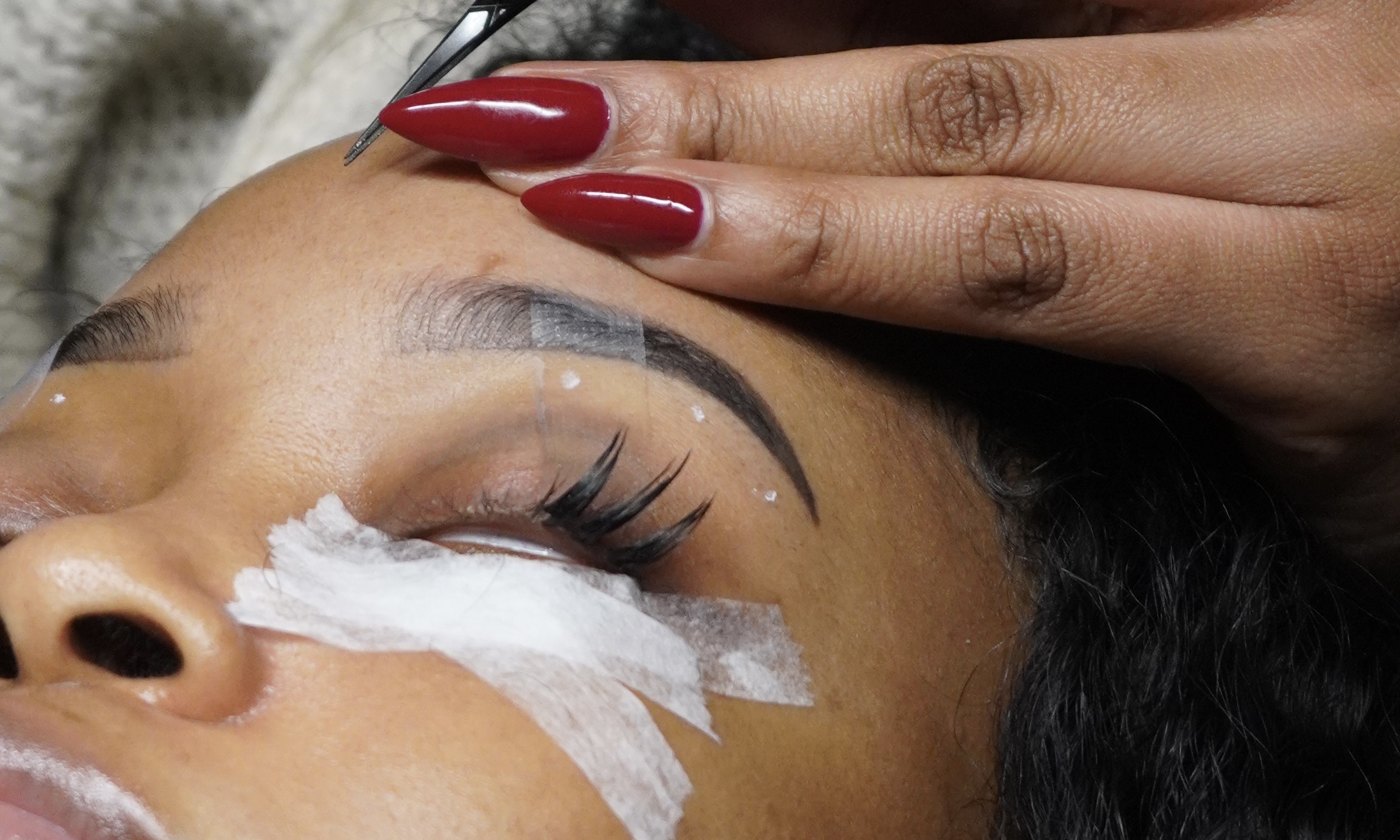 Lash artist carefully applying extensions